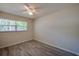 Empty bedroom featuring a large window, ceiling fan, neutral paint, and wood-look flooring at 818 Sugar House Blvd, Port Orange, FL 32129