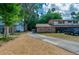 Inviting brick home with a lengthy driveway, surrounded by vibrant greenery beneath a partly cloudy sky at 818 Sugar House Blvd, Port Orange, FL 32129