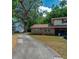 Charming brick home with a long driveway and lush green surroundings under a partly cloudy sky at 818 Sugar House Blvd, Port Orange, FL 32129