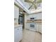 Kitchen with white cabinets, tile flooring, appliances, and a nearby laundry area at 818 Sugar House Blvd, Port Orange, FL 32129