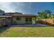 View of the backyard with a partial fence, grass, and a door to the house at 834 Sugar House Dr, Port Orange, FL 32129