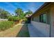View of the exterior and side yard featuring a brick accent wall and mature landscaping at 834 Sugar House Dr, Port Orange, FL 32129