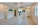 Open-concept living room showcasing tile flooring, modern light fixture, and view of kitchen at 834 Sugar House Dr, Port Orange, FL 32129
