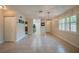 Bright living room with tile flooring, chandelier, front door and windows; kitchen in the background at 834 Sugar House Dr, Port Orange, FL 32129