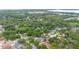A high angle aerial view featuring a residential neighborhood surrounded by lush greenery and mature trees at 9720 Fairway Cir, Leesburg, FL 34788
