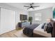 Comfortable bedroom with a ceiling fan, closet, and a large window for natural light at 9720 Fairway Cir, Leesburg, FL 34788