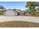 Well-maintained single-Gathering home featuring a two-car garage and manicured front lawn at 9720 Fairway Cir, Leesburg, FL 34788