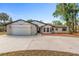 Single-Gathering home featuring a two-car garage and front yard at 9720 Fairway Cir, Leesburg, FL 34788
