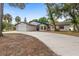 Single-story home with a long driveway, 2-car garage, and landscaped front yard at 9720 Fairway Cir, Leesburg, FL 34788