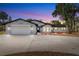 Charming single-story home boasts a manicured lawn, well-lit facade, and attached two-car garage at 9720 Fairway Cir, Leesburg, FL 34788