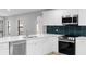 Bright kitchen features white cabinets, stainless steel appliances, white countertops, and blue tile backsplash at 9720 Fairway Cir, Leesburg, FL 34788