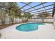 Screened pool with blue tile and bright blue water, surrounded by white concrete patio at 9720 Fairway Cir, Leesburg, FL 34788