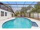 A pristine blue pool is enclosed with a screened cage and surrounded by a white concrete patio at 9720 Fairway Cir, Leesburg, FL 34788