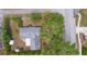 Aerial view of the house with a gray roof and mature trees surrounding the property at 990 W French Ave, Orange City, FL 32763