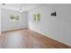 This spacious bedroom has hardwood floors, two windows and a ceiling fan at 990 W French Ave, Orange City, FL 32763