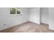 Bright bedroom featuring new carpet, large window, and a spacious closet at 990 W French Ave, Orange City, FL 32763