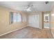 Bright bedroom featuring new carpet, a ceiling fan, and a well-lit attached bathroom at 990 W French Ave, Orange City, FL 32763