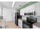 Modern kitchen with white cabinets, granite countertops, black appliances, and plenty of storage space at 990 W French Ave, Orange City, FL 32763