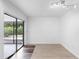 Bright living room with sliding glass doors leading to screened patio, wood-look flooring at 990 W French Ave, Orange City, FL 32763