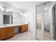 Bathroom with tile floors, wood cabinets, double sinks, and glass shower at 1120 W Glen Falls Rd, Deland, FL 32720