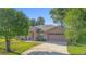 Charming brick home featuring an attached garage and well-manicured front yard with mature shade trees at 1120 W Glen Falls Rd, Deland, FL 32720