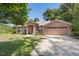 Inviting single-story brick home with a long driveway and mature landscaping in a lush green setting at 1120 W Glen Falls Rd, Deland, FL 32720