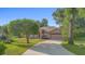 Charming brick home featuring an attached garage and well-manicured front yard with mature shade trees at 1120 W Glen Falls Rd, Deland, FL 32720