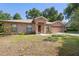 Attractive single-story brick home featuring a manicured lawn, front garden beds and an attached garage at 1120 W Glen Falls Rd, Deland, FL 32720