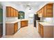 Bright kitchen features wooden cabinets, white appliances, and a view to the laundry area at 1120 W Glen Falls Rd, Deland, FL 32720