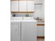 Functional laundry room with washer, dryer, sink, and upper cabinets for storage at 1120 W Glen Falls Rd, Deland, FL 32720