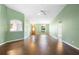 A spacious living room with pass-through to the kitchen featuring high ceilings, laminate wood flooring, and ceiling fan at 1120 W Glen Falls Rd, Deland, FL 32720