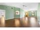 Spacious living room with hardwood floors, ceiling fan, and view to the kitchen and front entrance at 1120 W Glen Falls Rd, Deland, FL 32720