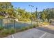 Community tennis court surrounded by lush trees and parking area at 1120 W Glen Falls Rd, Deland, FL 32720