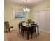 Inviting dining room with modern chandelier, table with seating for six, carpet and a large picture at 119 Fishermans Cove Dr, Edgewater, FL 32141