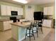 Bright kitchen features white cabinets, black appliances, an island with seating, and tile flooring at 119 Fishermans Cove Dr, Edgewater, FL 32141