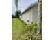 Well-maintained side yard with lush landscaping and manicured lawn, enhancing the home's curb appeal at 119 Fishermans Cove Dr, Edgewater, FL 32141