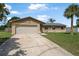 Charming home featuring a two car garage, well-maintained lawn and palm tree at 1191 Tracy Dr, Port Orange, FL 32129