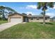 Well-kept home with a 2-car garage, stone accents and a neatly manicured front lawn at 1191 Tracy Dr, Port Orange, FL 32129