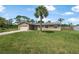 Charming single-story home featuring a well-manicured lawn and a majestic palm tree in the front yard at 1191 Tracy Dr, Port Orange, FL 32129
