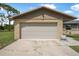Close up of the front of a two car garage with stone accents and a paved driveway at 1191 Tracy Dr, Port Orange, FL 32129