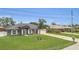 Charming single-story home featuring a well-manicured lawn and a central palm tree at 1194 Balfour Dr, Deltona, FL 32725