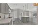 Bright kitchen with stainless steel appliances, gray cabinets, and island with sink at 1194 Balfour Dr, Deltona, FL 32725