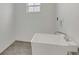 The laundry room is ready for use with a utility sink, tiled floor, and a patterned glass window at 1194 Balfour Dr, Deltona, FL 32725