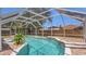 View of the screened in private pool with brick paver patio, surrounded by lush greenery at 1194 Balfour Dr, Deltona, FL 32725