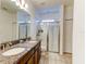 Bathroom featuring double sinks with granite countertops, and glass enclosed walk-in shower at 12079 Alder Branch Loop, Orlando, FL 32824