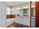 Bright bathroom with double vanity, soaking tub, and tile accents, offering a luxurious and comfortable space at 1233 Girog Ave, Port Orange, FL 32129
