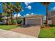 Charming single-story house with a two-car garage, brick driveway, and beautifully landscaped front yard with palm trees at 1233 Girog Ave, Port Orange, FL 32129