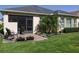 Charming backyard patio with chairs, a potted plant, and lovely garden with colorful flowers at 1386 Brayford Pt, Deland, FL 32724