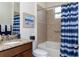 Bathroom featuring granite countertops, under-mount sink, framed beach art, and shower/tub combo at 1386 Brayford Pt, Deland, FL 32724