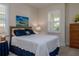 Cozy bedroom with plush carpeting, window with plantation shutters, and wicker headboard at 1386 Brayford Pt, Deland, FL 32724